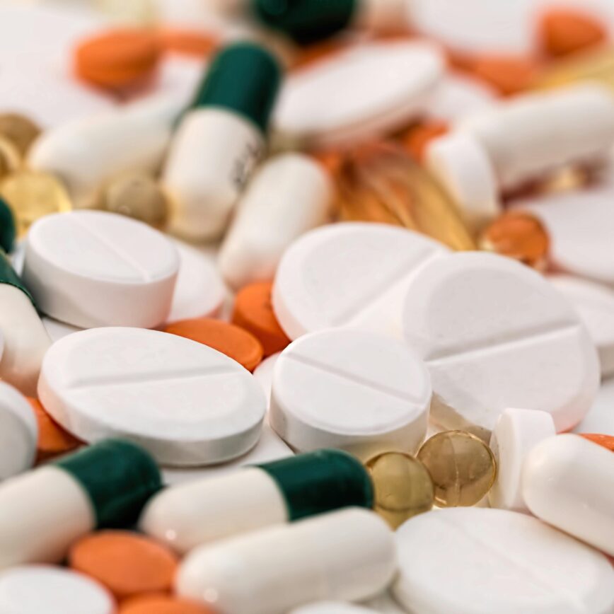 Close-up of various pills and capsules in different colors and sizes, ideal for healthcare-related content.