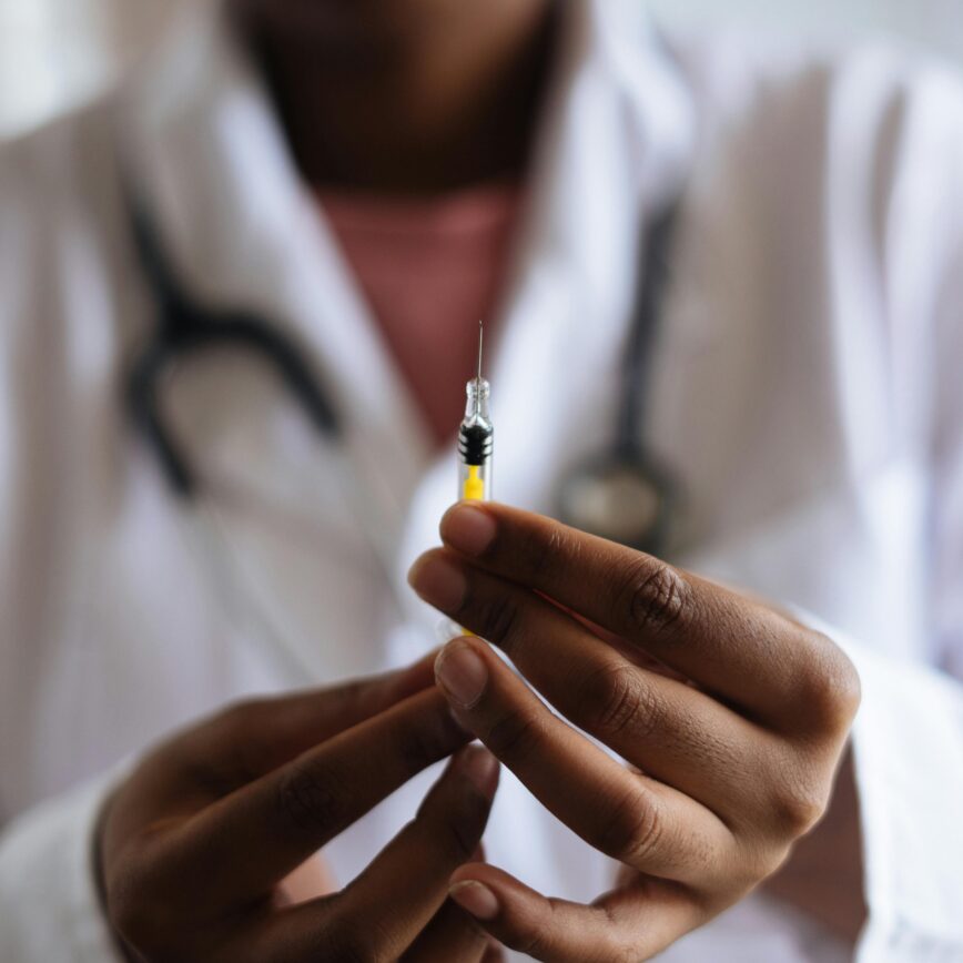 Close-up of a healthcare professional holding a syringe, symbolizing medical care and vaccination.