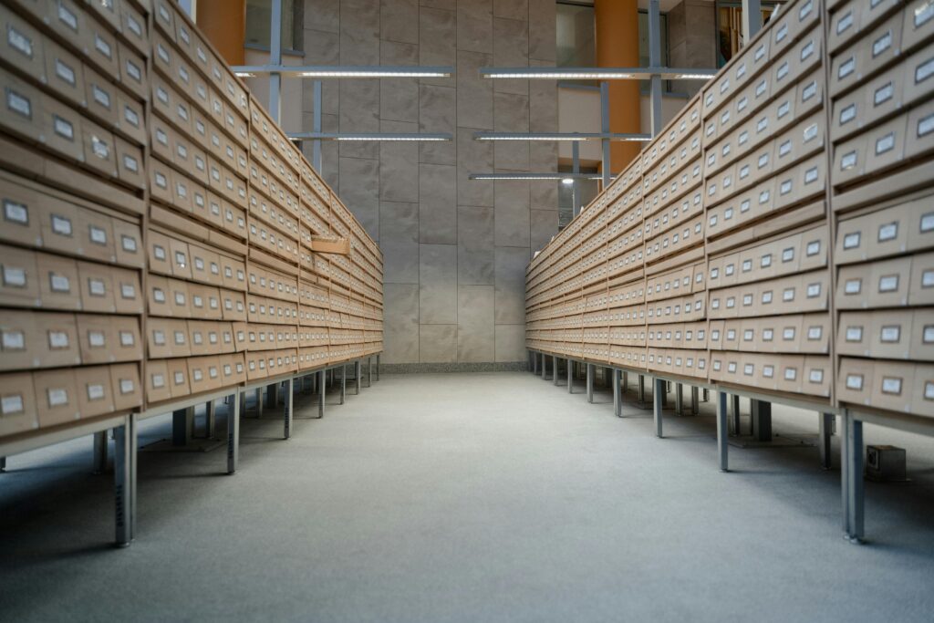 pexels-photo-6549926-6549926 Spacious modern library archive with rows of wooden drawers for document storage.