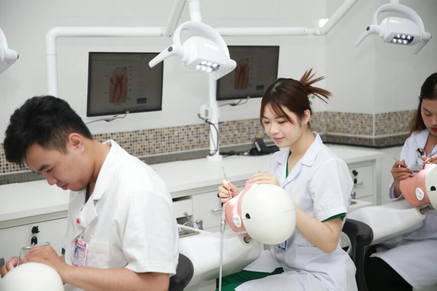 Dental students practicing procedures on training models in a classroom setting.
