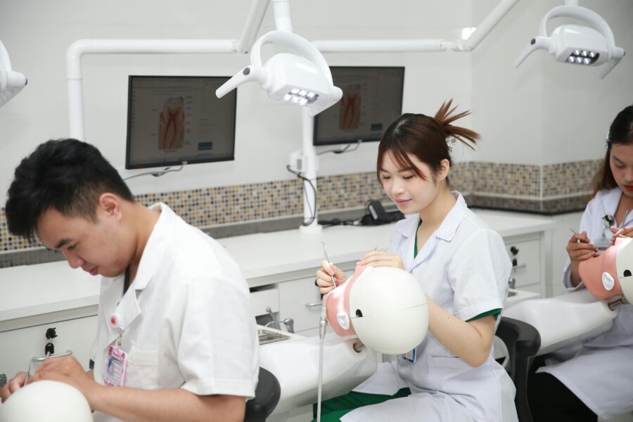 Dental students practicing procedures on training models in a classroom setting.